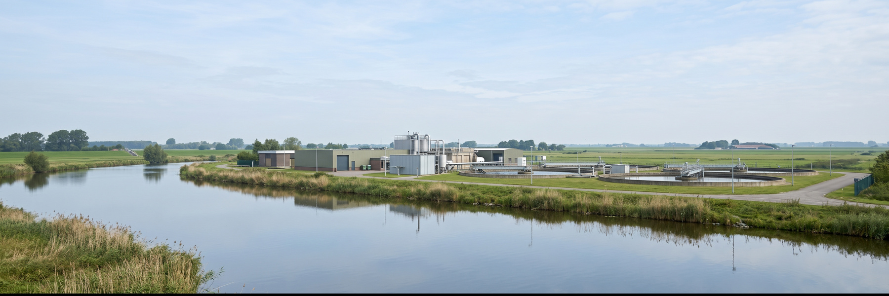 Water treatment plant beside a calm river in flat Dutch countryside