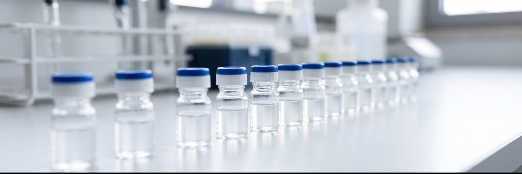 Row of clear water sample vials on a laboratory bench