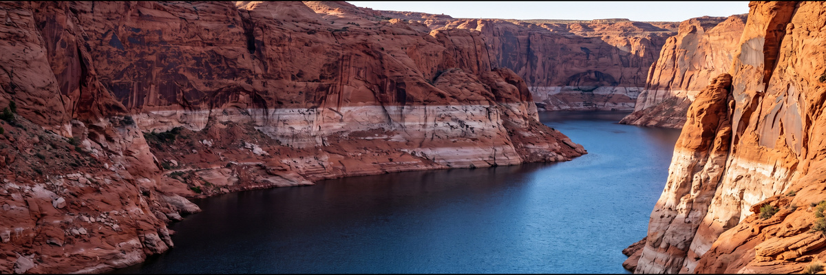 Pale mineral ring on canyon walls above a low reservoir
